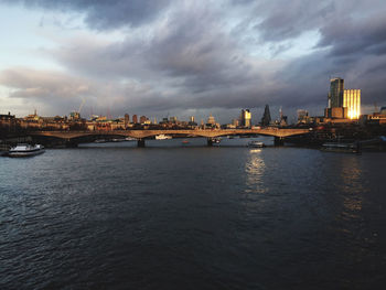 Bridge over river thames by london against sky at dusk