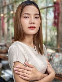 Portrait of a beautiful young woman cross arm ,look down in a bright restaurant