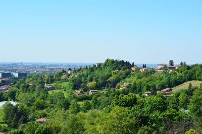 Scenic view of town by sea against clear sky