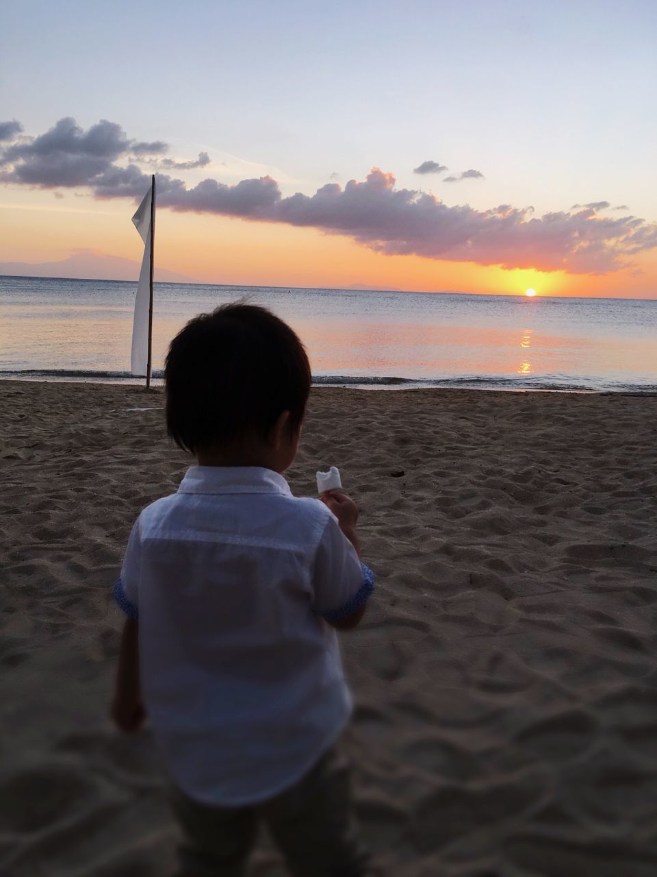 rear view, sea, sunset, water, beach, sky, one person, waist up, boys, reflection, childhood, males, real people, silhouette, one boy only, horizon over water, lifestyles, scenics, leisure activity, outdoors, beauty in nature, nature, people, day