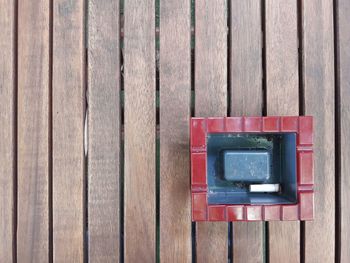 Close-up of red mailbox on wood