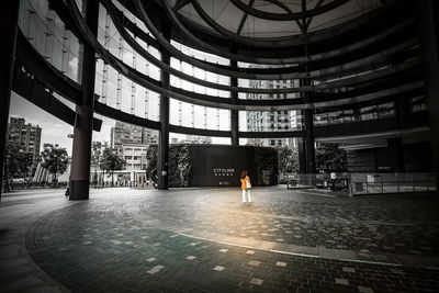 Rear view of man standing by modern building in city