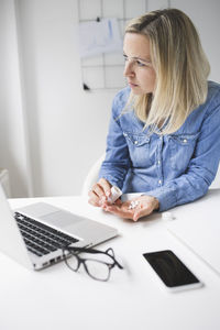 Frustrated businesswoman having medicine while working from home