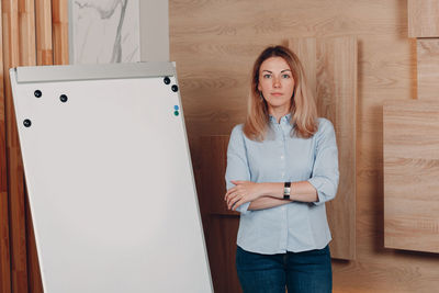 Portrait of young woman using digital tablet in office