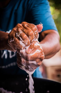 Midsection of man making coconut juice