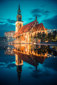 Reflection of illuminated buildings in city at dusk