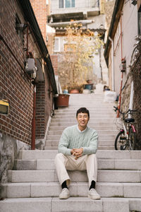 Portrait of young man sitting on staircase