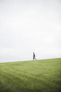 Man playing soccer on field against sky