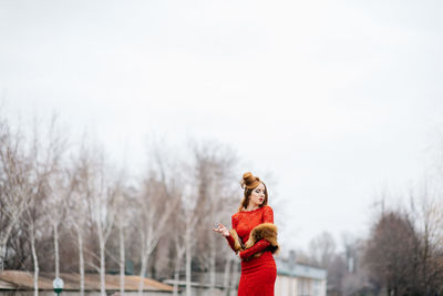 Portrait of woman standing against sky