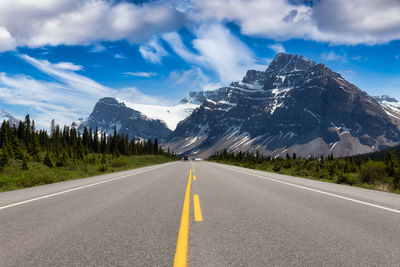 Surface level of road by mountain against sky