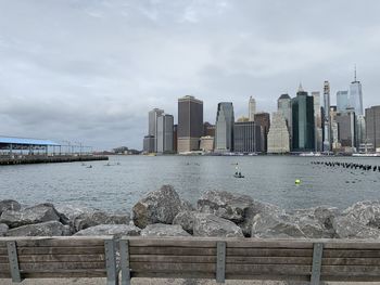 View of modern buildings by sea against sky