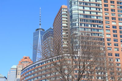 Low angle view of modern buildings in city on sunny day