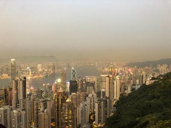 Aerial view of city lit up against sky