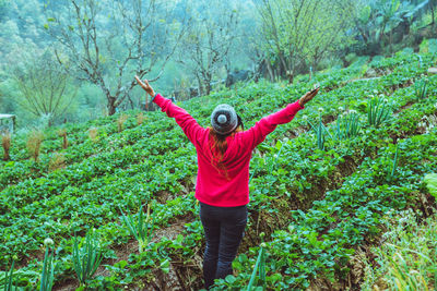 Full length of woman standing by plants