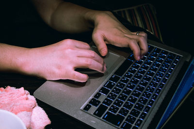 Midsection of woman using laptop typing keyboard
