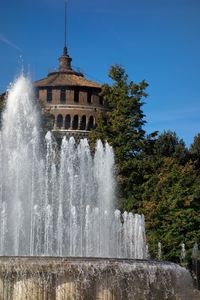 Water splashing fountain against sky