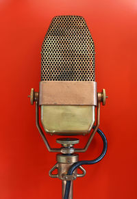 Close-up of microphone against red background