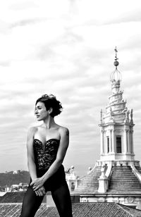 Young woman standing against building