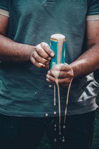 Midsection of man holding drink can