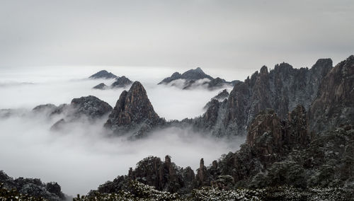 Scenic view of mountains during foggy weather against sky