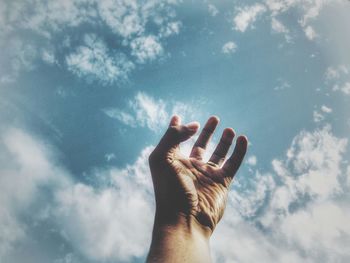 Low angle view of hand against sky