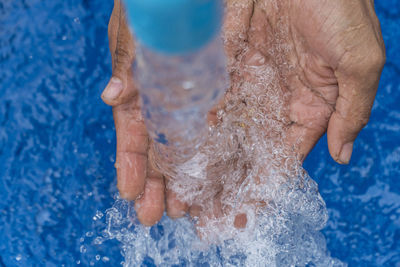 Close-up of person hand in swimming pool