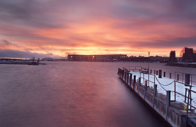 View of harbor against cloudy sky during sunset