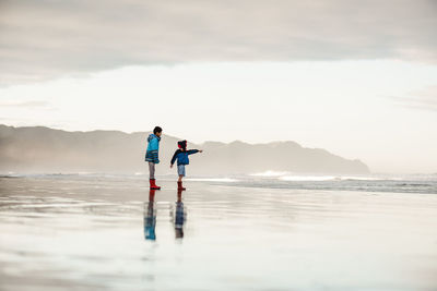 Brothers at beach in new zealand on winter day