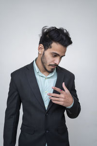 Young man looking away against white background