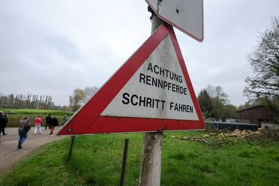 Road sign on field against sky