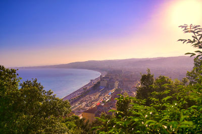 High angle view of buildings and sea against sky at sunset