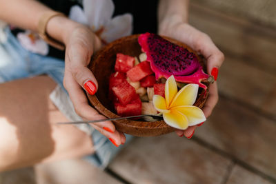 High angle view of woman holding red rose