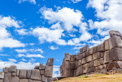 Low angle view of sacsayhuaman ruins against cloudy blue sky