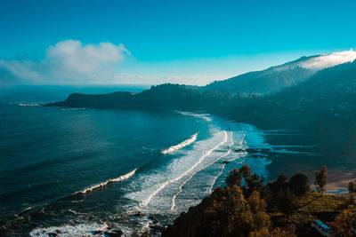 Panoramic view of sea and mountains against blue sky