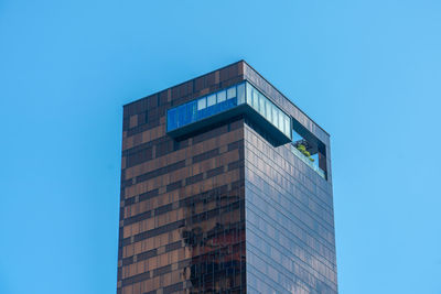 Low angle view of modern building against clear blue sky