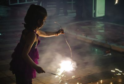 Girl playing with burning sparkler