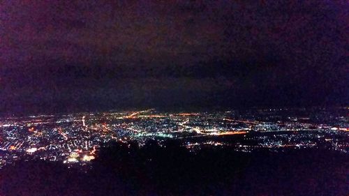 Close-up of illuminated city against sky at night