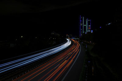 High angle view of light trails on street amidst buildings at night