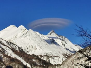 Scenic view of snowcapped mountains against clear blue sky