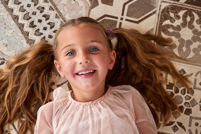 Girl with blue eyes lies on floor dreaming about future