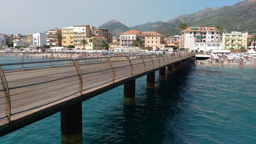 Pier by sea against buildings in city