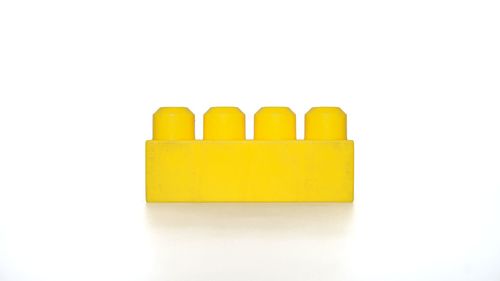 Close-up of yellow toy over white background