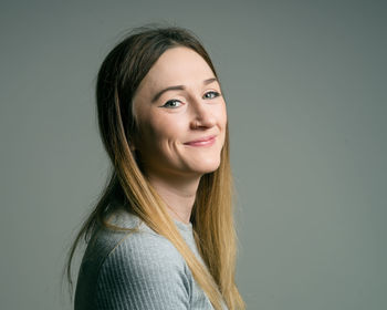 Portrait of young woman against white background