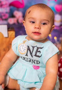 Portrait of cute baby girl sitting on hardwood floor 