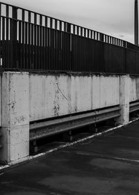 Road by wall against sky in city