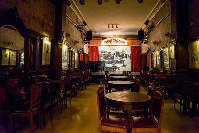 Empty chairs and tables in illuminated building