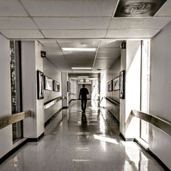 Rear view of man walking in corridor of building