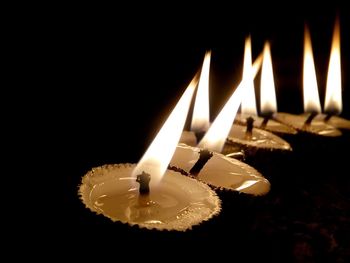 Close-up of lit candle in dark room