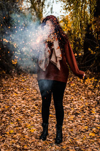 Full length of woman standing on road during autumn