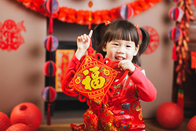 Portrait of cute girl holding fabric with text